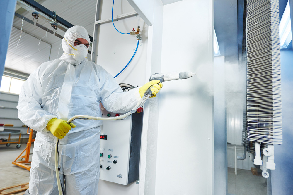 Man In Protective Suit Applying Powder Coating