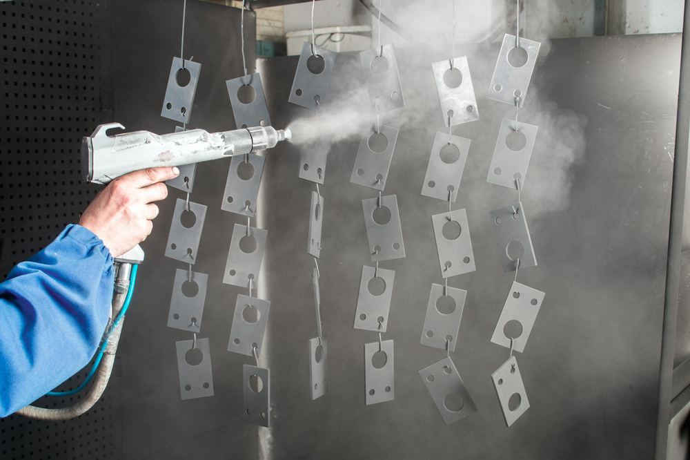 A man doing powder coating of metal parts